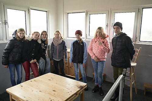 Sieben Schüler*innen stehen im Inneren des Grenzturms